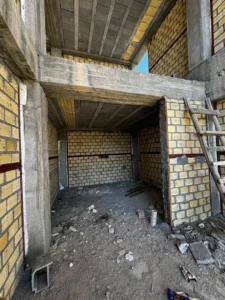 Evening exterior view highlighting architectural lighting and textures.